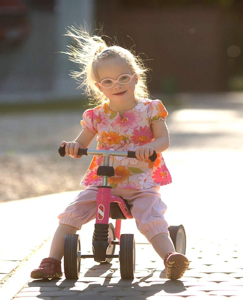 young girl on tricycle