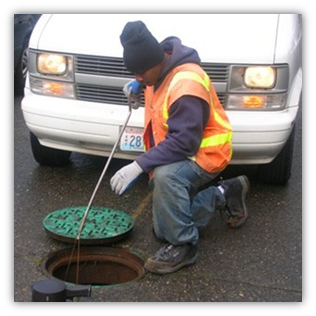 Staff setting rat bait in Seattle sewer system