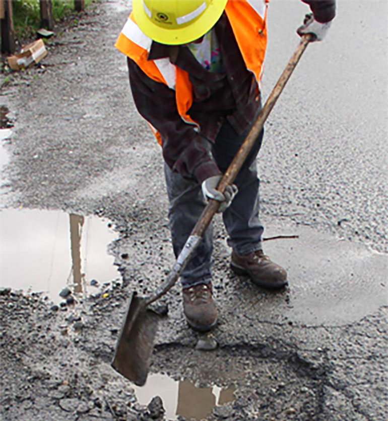 Crew member repairing a pothole