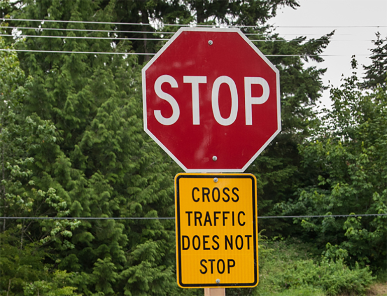 Stop sign and sign indicating cross traffic does not stop.