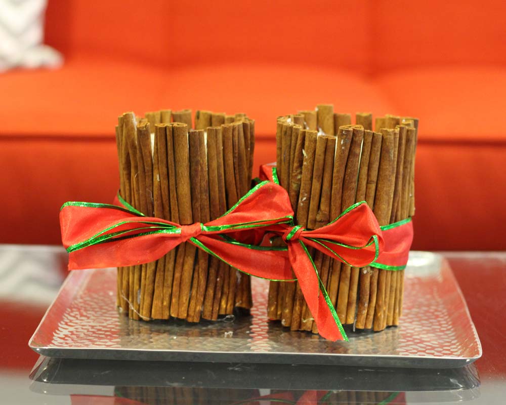 image of candles wrapped in cinnamon sticks and ribbon - link to Celebrate green & safe
