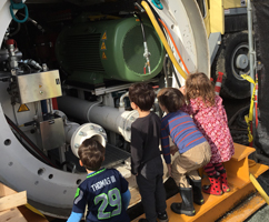 Kids looking at a tunnel boring machine
