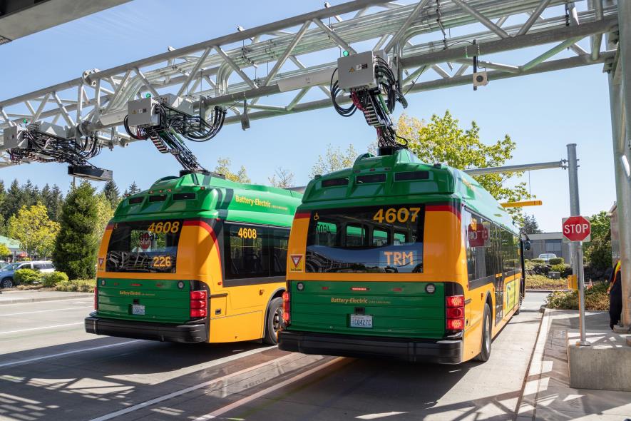 Two King County Metro electric buses at a charging station.