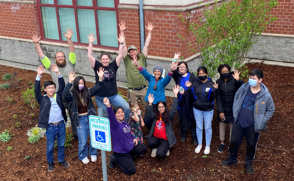 Standing in front of their school, a group of students, teachers, and community members celebrate the completion of the rain garden that was funded by a King County WaterWorks Grant. 