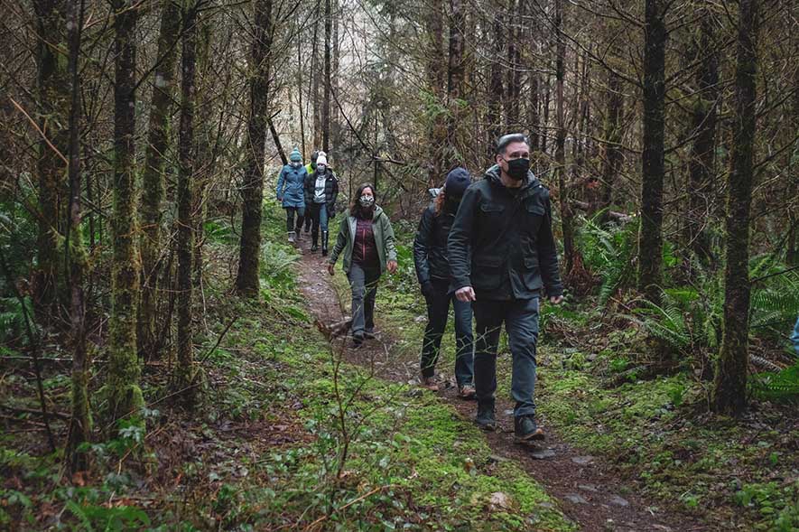 Dow Constantine walking through the woods with colleagues.
