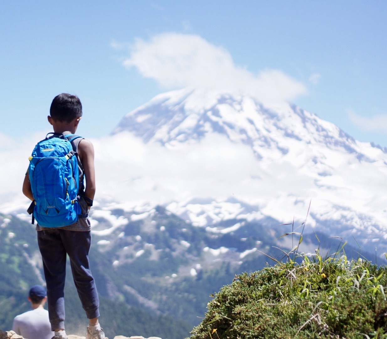 A boy on a hike looking at Mount Rainier.