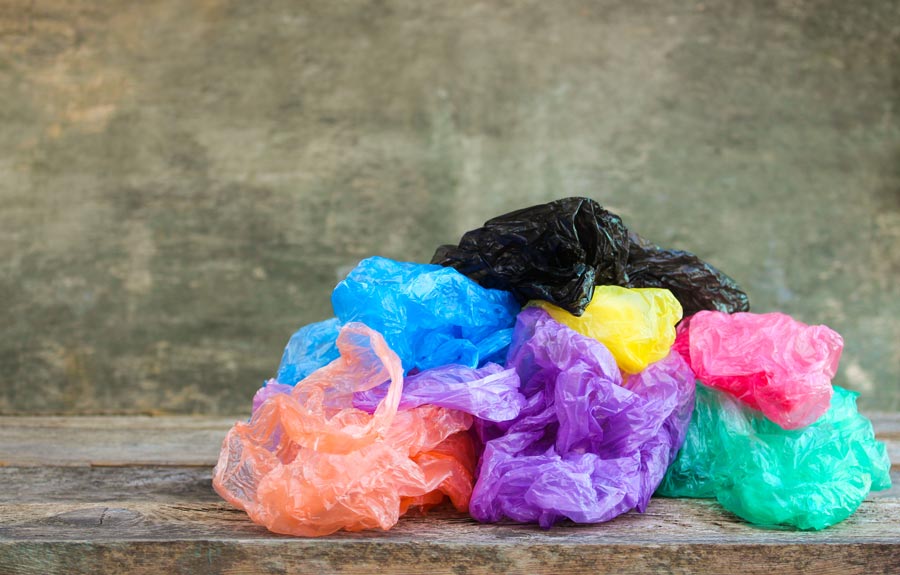 No plastic bags or wrap in the recycling bin - image showing a pile of plastic shopping bags