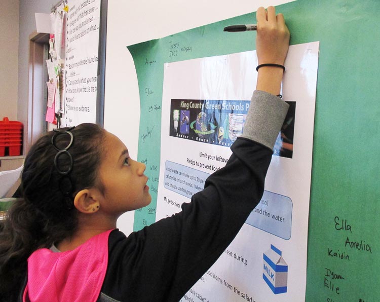 Student signing pledge to reduce food waste at school