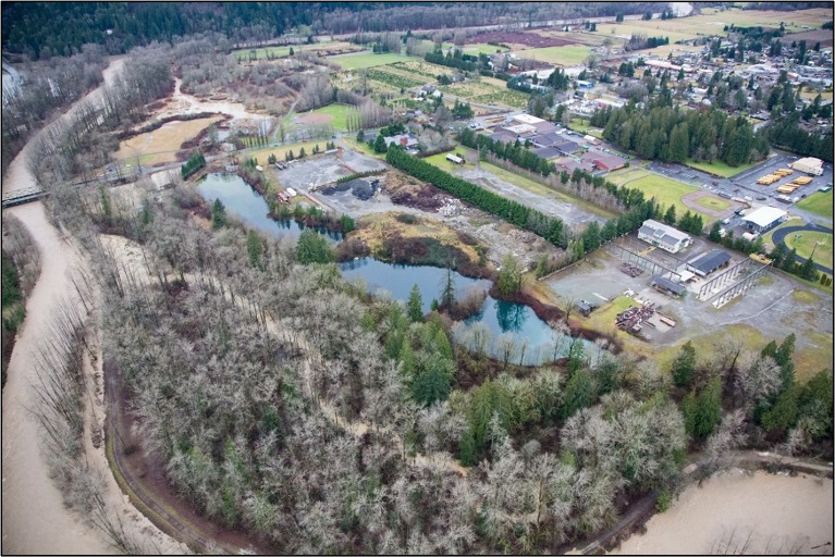 Aerial photo of the Tolt River in the foreground, the Lower Frew Levee project site, SR 203 to the left, and the City of Carnation to the north.