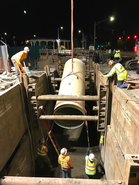 sewer pipe being placed in the trench