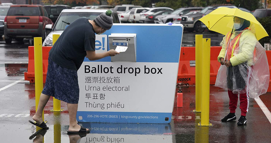 Voter returning ballot at ballot drop box