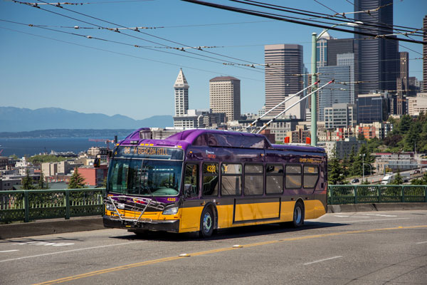 Electric bus driving up the Jose Rizal Bridge with Downtown Seattle in the background