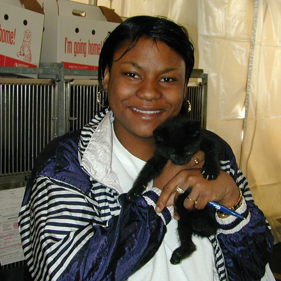 Smiling girl holding black kitten