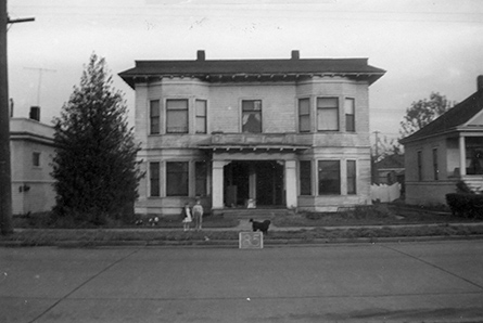 Street view of white, two-story apartment building
