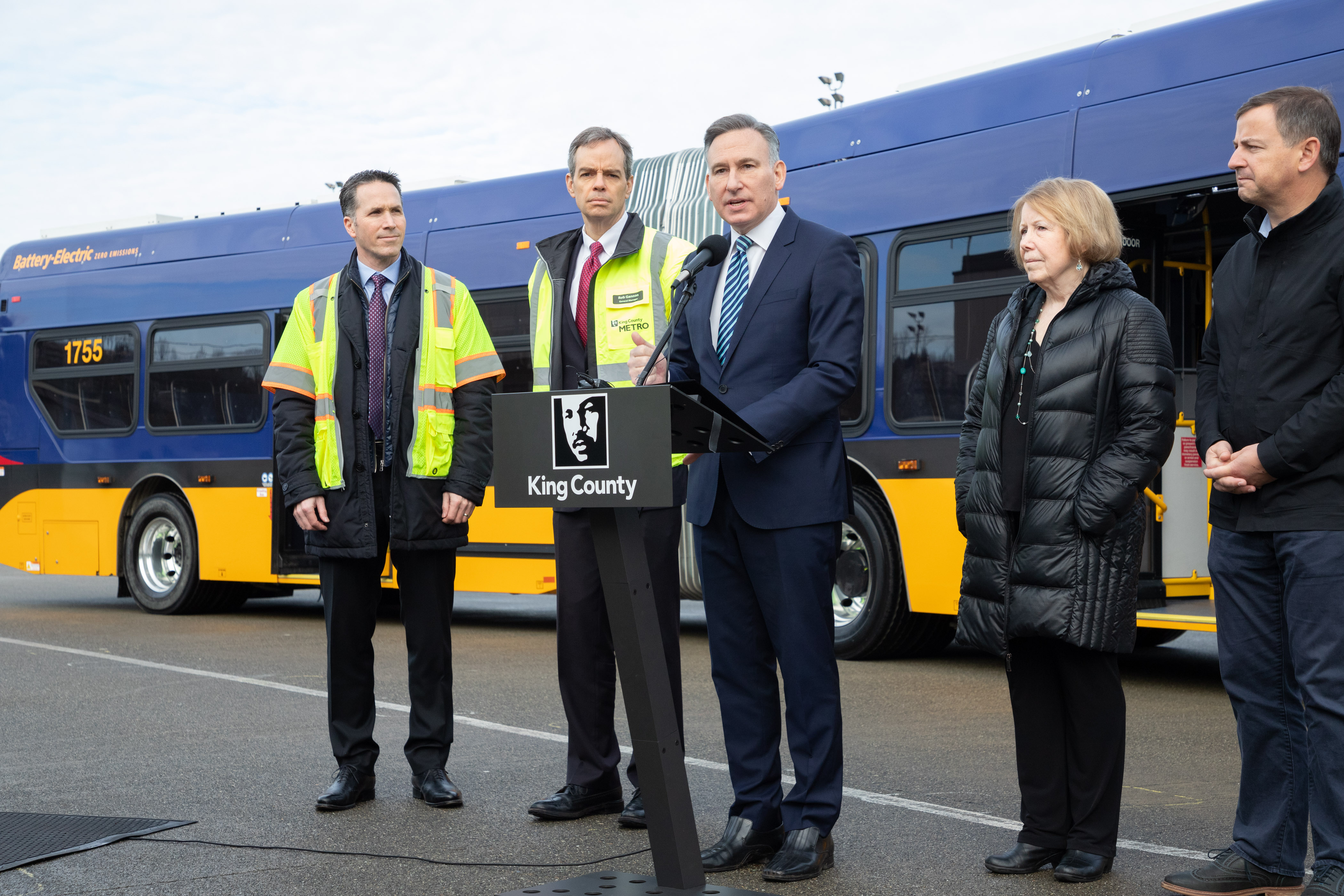 Dow Constantine and others gathered in front of a battery-electric bus.
