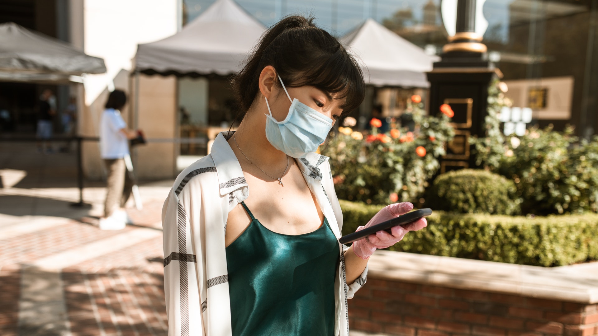 Woman in facemask holding phone